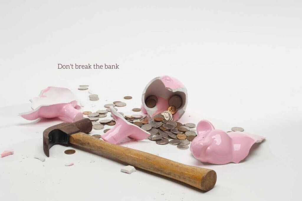 broken piggy bank with hammer and change spilled