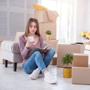 girl on phone sitting next to boxes