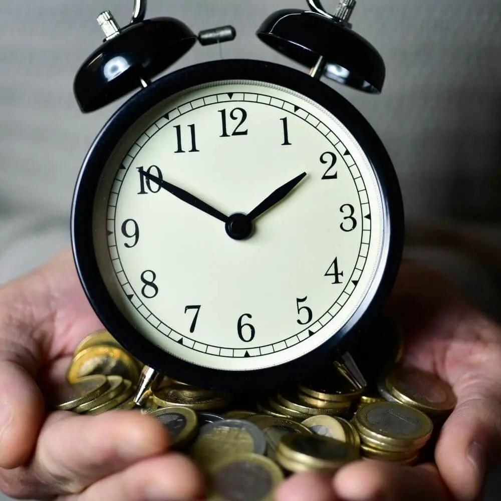 hands holding a clock and money