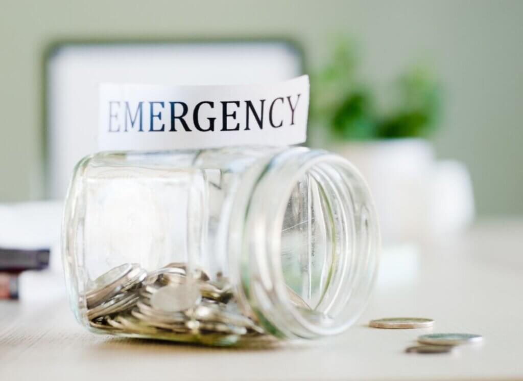 jar tipped over with change inside and an emergency sign