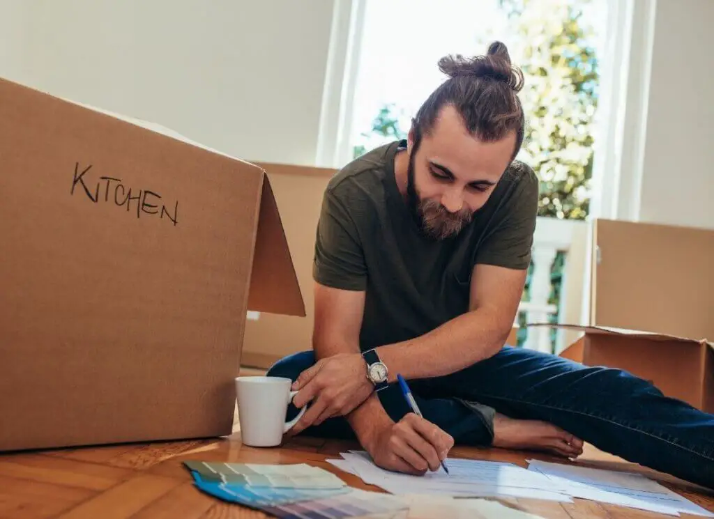 moving box next to a man working on a checklist