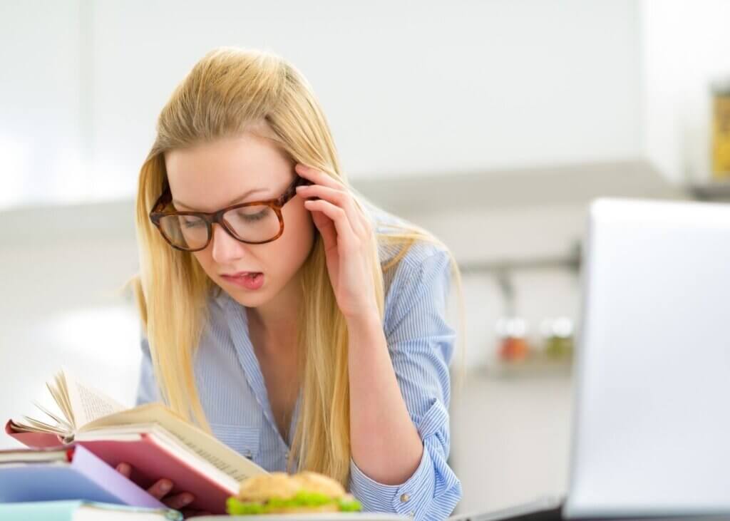 girl with glasses studying a book