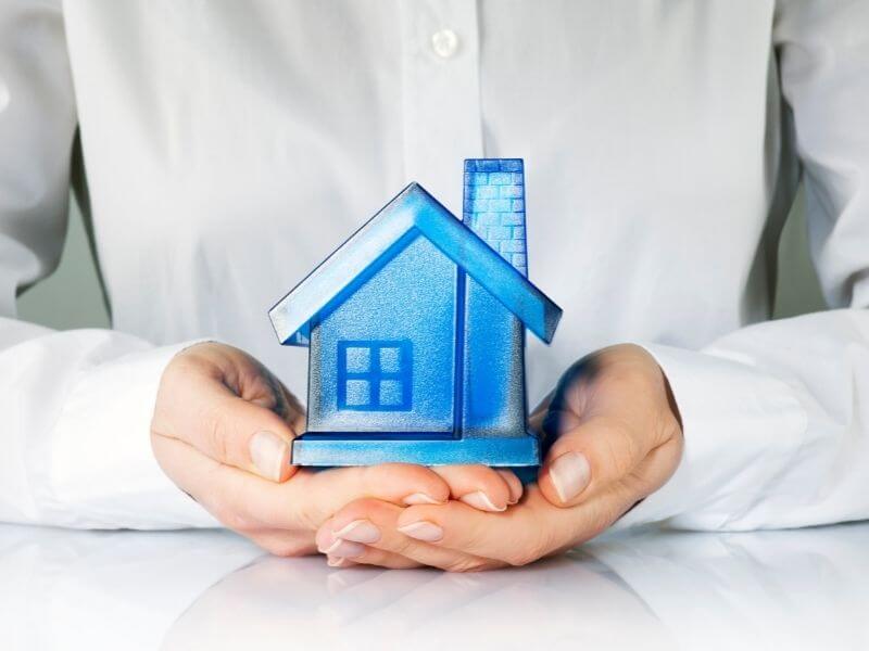 hands holding a blue glass house